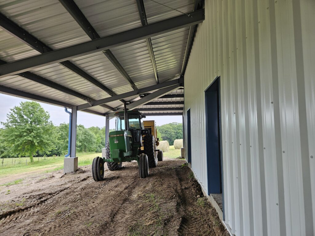 This 80'x80' steel building includes a wrapped 20' canopy porch on three sides. The main building has an 18" overhang and soffit on each side with gutters & downspouts. There is a 14'x14' slider door on the back side, 8'x8' opening on the other end, (6) 4x8 sidewall openings for individual horse stalls, a small window on each end and one 3070 walk door. The barn colors are Hawaiian Blue roof & trims with Polar White walls.
